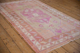 Pink blossom medallion and starbursts on a distressed vintage Oushak rug.