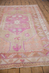 Distressed vintage Oushak rug: pink germinating blossoms in the center medallion.