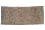 Vintage distressed Oushak rug runner with repeating geometric medallions in ivory, powder blue, and brown.
