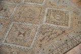 Distressed pile texture of an Oushak rug with geometric gul and hook motifs.