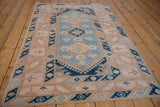 Distressed Melas rug's geometric floral border and central crab-inspired medallion detail.