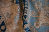 Distressed vintage Melas rug with powder blue geometric patterns on a dusty blush field.