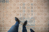 Distressed Oushak runner showing blue geometric trellis and starburst border, with soft abrashes.