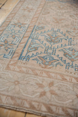 Textured distressed Oushak runner's geometric floral blossom and lattice panels, dusty blue and pale bronze.