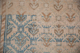 Vintage Oushak rug's geometric floral trellis with dusty blue and bronze abrashes.