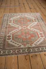Distressed Oushak corner view with geometric borders, checkered motifs, and even pile wear.