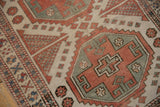 Distressed Oushak rug showcasing geometric medallion and checkered motifs in madder red, ivory, dusty blue.