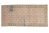 Vintage Oushak runner with a distressed geometric trellis pattern in ivory, seafoam, bronze, and blue.