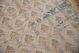 Detail of the distressed vintage Oushak rug's low pile and geometric pattern in muted tones.