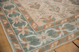 The seafoam green starburst and vine border of a distressed hand-knotted Oushak rug runner.