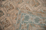 Flipped corner of a vintage Oushak runner showing its hand-knotted weave and distressed pile.