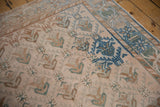 Angled view of a distressed Oushak runner's low pile, highlighting the trellis pattern and starburst border.