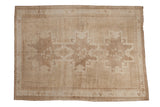 Distressed vintage Turkish Oushak carpet, triple starburst medallions, neutral beige tones.