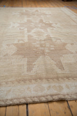 Faded stepped geometric floral medallion and short pile on vintage distressed Oushak rug.
