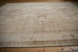 Distressed vintage Oushak rug showing short pile height and pale brown wave border.