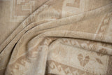 Soft, rumpled pile texture of the vintage distressed Oushak rug in pale coffee and ivory tones.