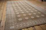 Coffee brown and ivory reciprocating wave border on a vintage distressed Oushak rug.