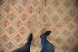 Distressed vintage Oushak rug with repeating pinwheel design in ivory, brick red, and silver.