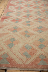 Distressed vintage Oushak rug featuring ivory, pale brick red, and silver geometric pattern.