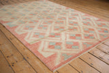 Contemporary distressed Oushak rug corner featuring ivory, pale brick red, and silver pawn design.