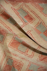 Distressed Oushak rug pile with ivory, pale brick red, and silver pinwheel motifs.