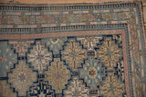 Antique Shirvan rug corner displaying intricate geometric borders, pawn design, and pomegranate starburst in navy, beige, pink.