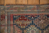 Antique Shirvan rug corner, with stylized animal border motifs, geometric patterns, and worn fringe.