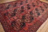 Vintage Ersari carpet's geometric gul motifs and diamond border in dusty blush and navy.