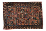Distressed vintage Farahan Sarouk rug with dusty rose floral field and serpent borders.