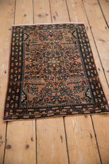 Distressed vintage Farahan Sarouk rug with detailed dusty rose floral sprays and vinery.