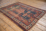 Abrashed red field, geometric pawn motif border, and frayed fringe on antique rug.