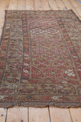 Antique hand-knotted Kurdish rug detail; geometric motifs, dusty red, and pile wear.