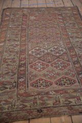 Antique Kurdish rug detail: geometric floral motifs in dusty wine, pale camel, with wear.