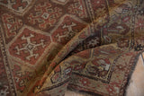 Repeating geometric floral design and characteristic pile wear on this antique Kurdish rug.
