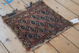 Antique Afshar rug mat detail: geometric starbursts, ivory, terra cotta, navy, and tattered edges.