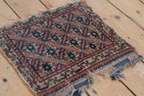 Tattered plain woven kilim edge and geometric starburst design of an antique Afshar rug.