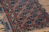 Antique Bagface Afshar rug with starburst motif, ivory tones, and frayed kilim edge.