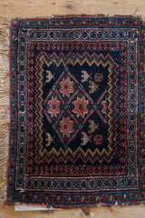 Afshar rug corner with geometric borders, terracotta starbursts, and reciprocating pawn motifs.