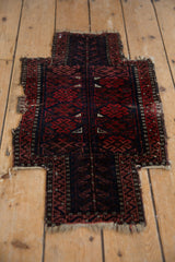 Antique Persian Belouch saddle cover with madder red and navy geometric design, showing tattered perimeter.