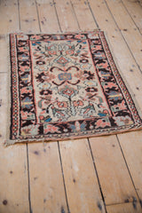Corner of vintage Lilihan rug with tattered fringe, charcoal border, and floral field.