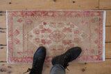 Distressed hand-knotted Oushak rug, pinwheel medallion and meandering vine border, ivory and pale red.