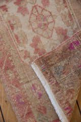 Distressed Oushak rug with worn beige pile, visible foundation, and knotted reverse.