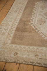 Vintage Distressed Oushak carpet, abrashed brown field, ivory wave border, and subtle faded motifs.