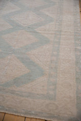Distressed pile texture of vintage Oushak rug, with faint ivory and pale sage geometric motifs.