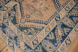 Distressed Vintage Melas rug with geometric hook and latch border, worn beige pile, and cobalt blue.