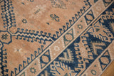 Distressed hand-knotted Melas rug border and field with cobalt blue geometric hook and latch motifs.