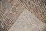 Distressed Oushak rug runner's textured pile in beige and mauve, revealing hand-knotted foundation.