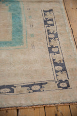 Vintage Oushak rug corner detail, revealing short pile with aqua and dark slate blue motifs.