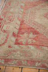 Abrashed dusty raspberry red and ivory tones on the evenly worn pile of a vintage Oushak rug.
