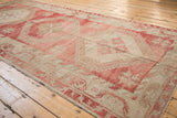 Perspective view of a distressed Oushak runner showing its abrashed texture and geometric design.